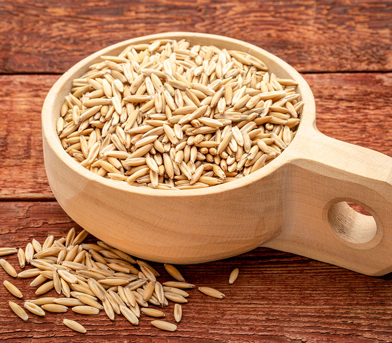 Oats in a wooden bowl on a wooden background.