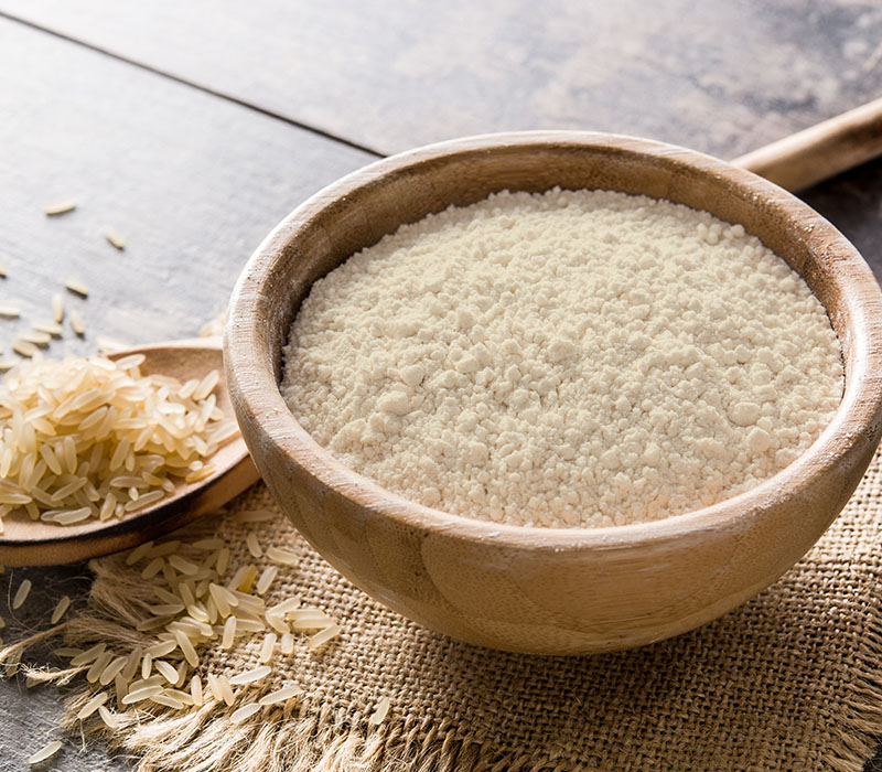 A bowl of rice protein powder with rice on the side