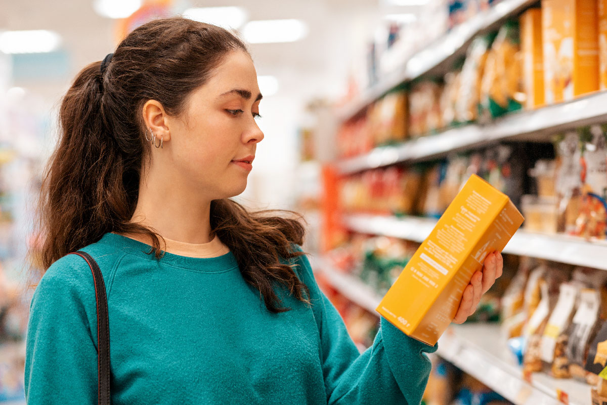 A lady in a green blouse ready the menu inscription on a product item