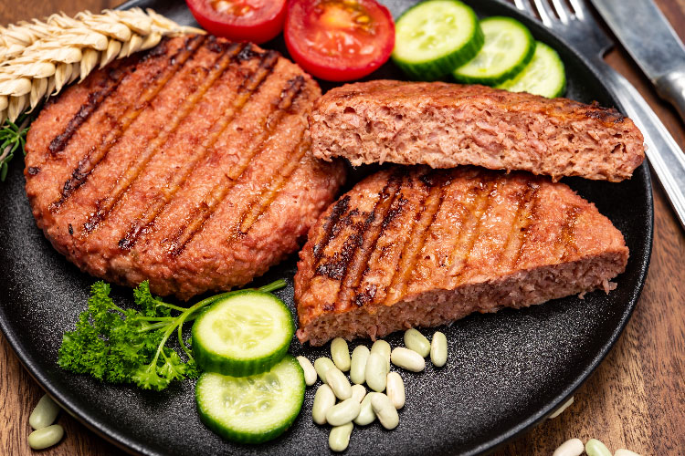 plant based steaks served with cucumber and tomatoes